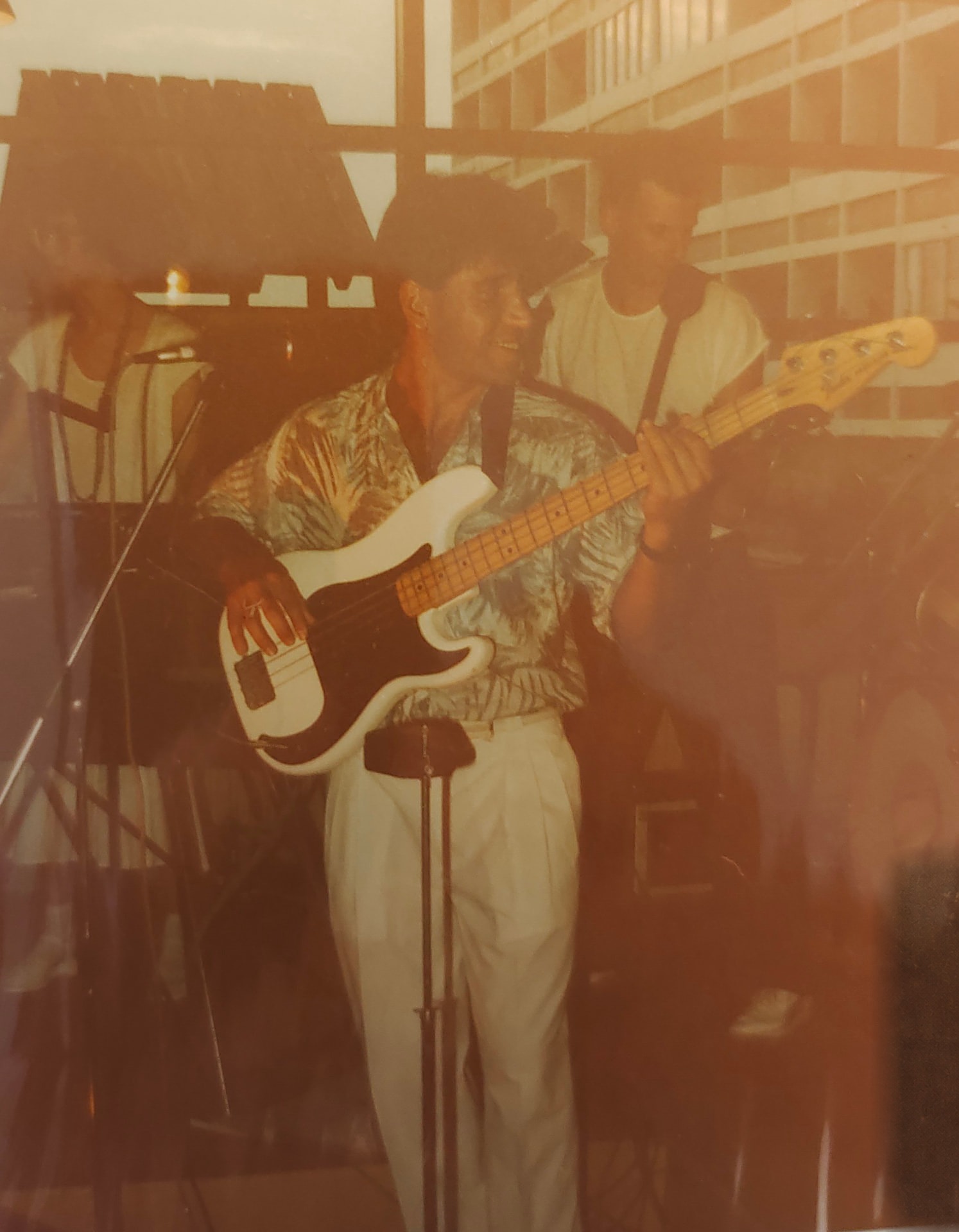 Joan Marc tocando un bajo eléctrico blanco en un escenario interior, junto a otros músicos.