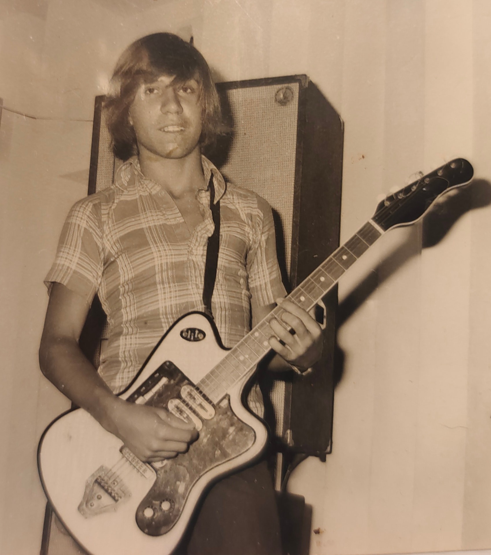 Joan Marc de pie tocando la guitarra eléctrica frente a un gran bafle en una sala interior.