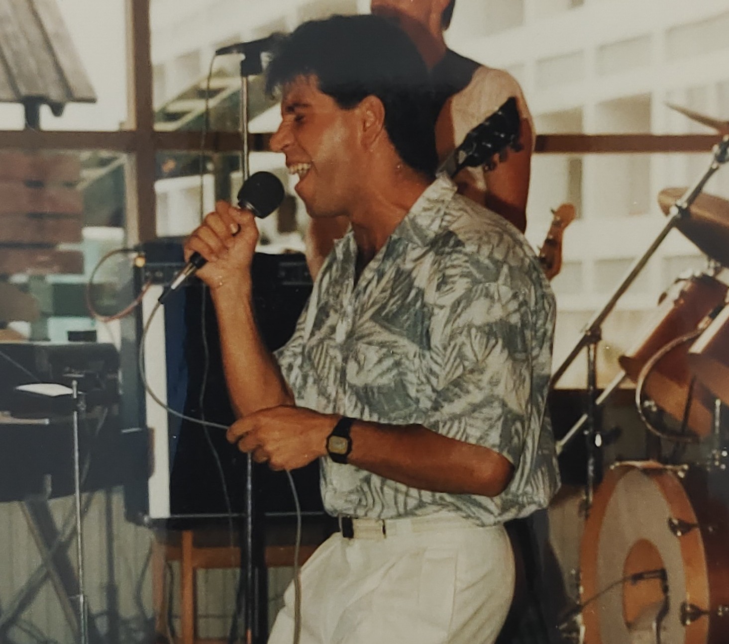 Joan Marc de perfil cantando con un micrófono en la mano, junto a otros músicos.